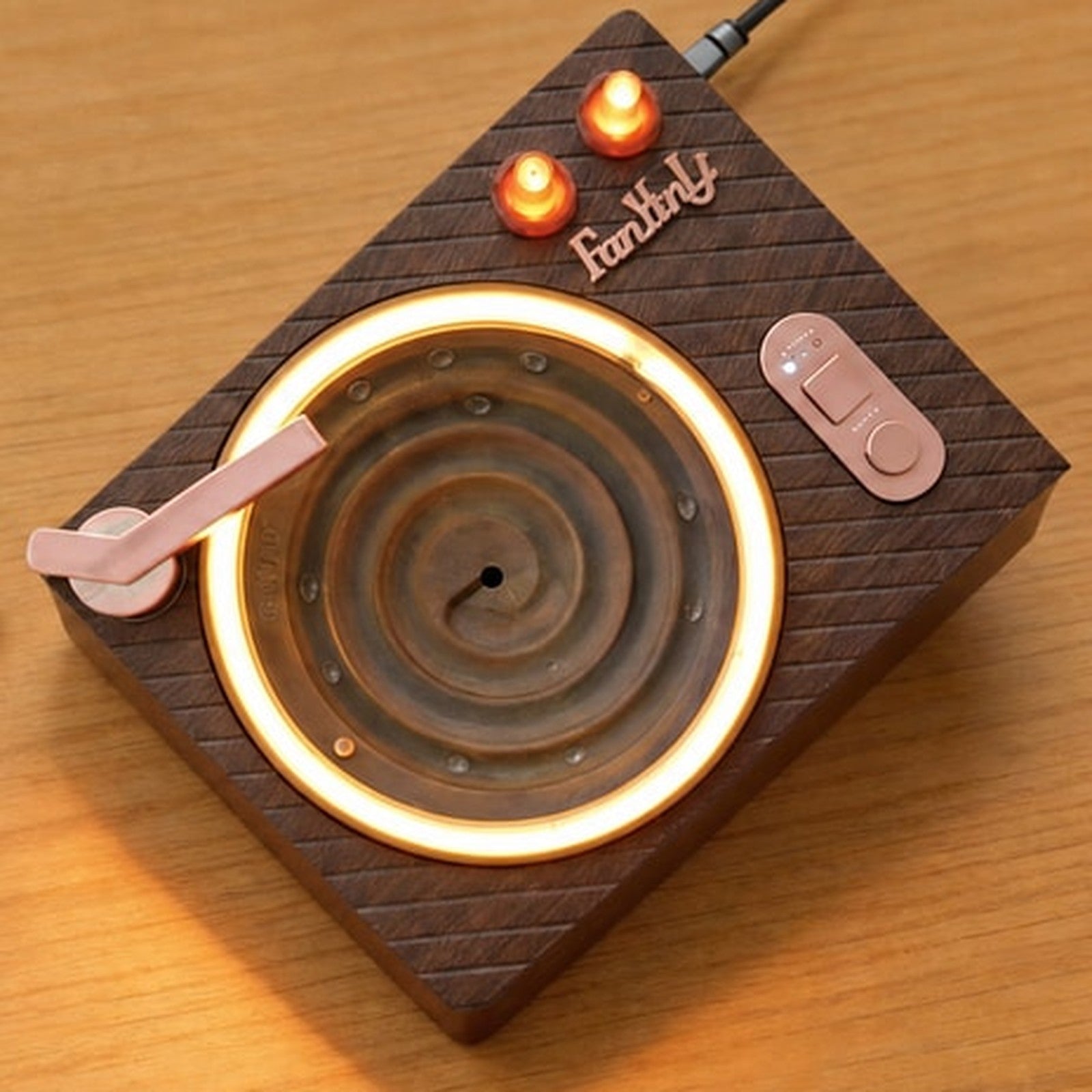 Retro wood-grain water drop ambient player with a warm glowing ring and RGB glass chambers on a wooden desk